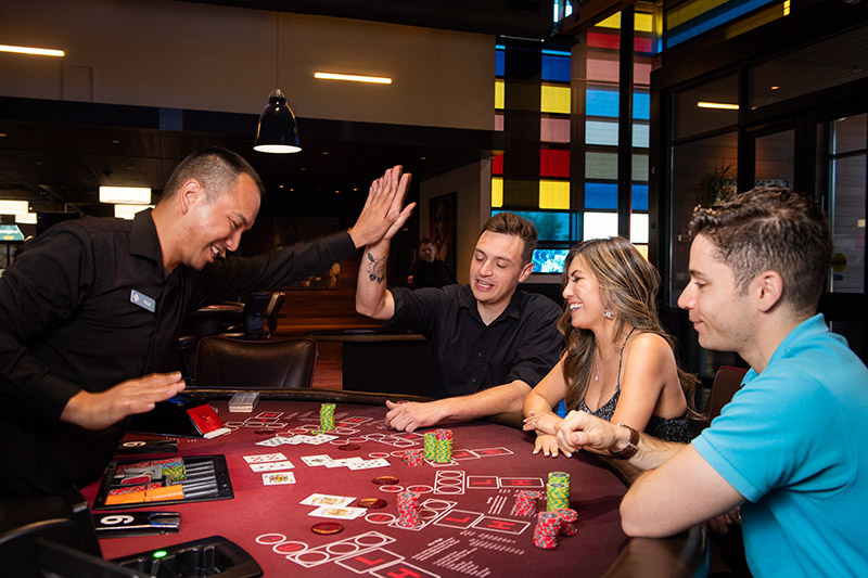 Dealer and player high fiving at a black jack table