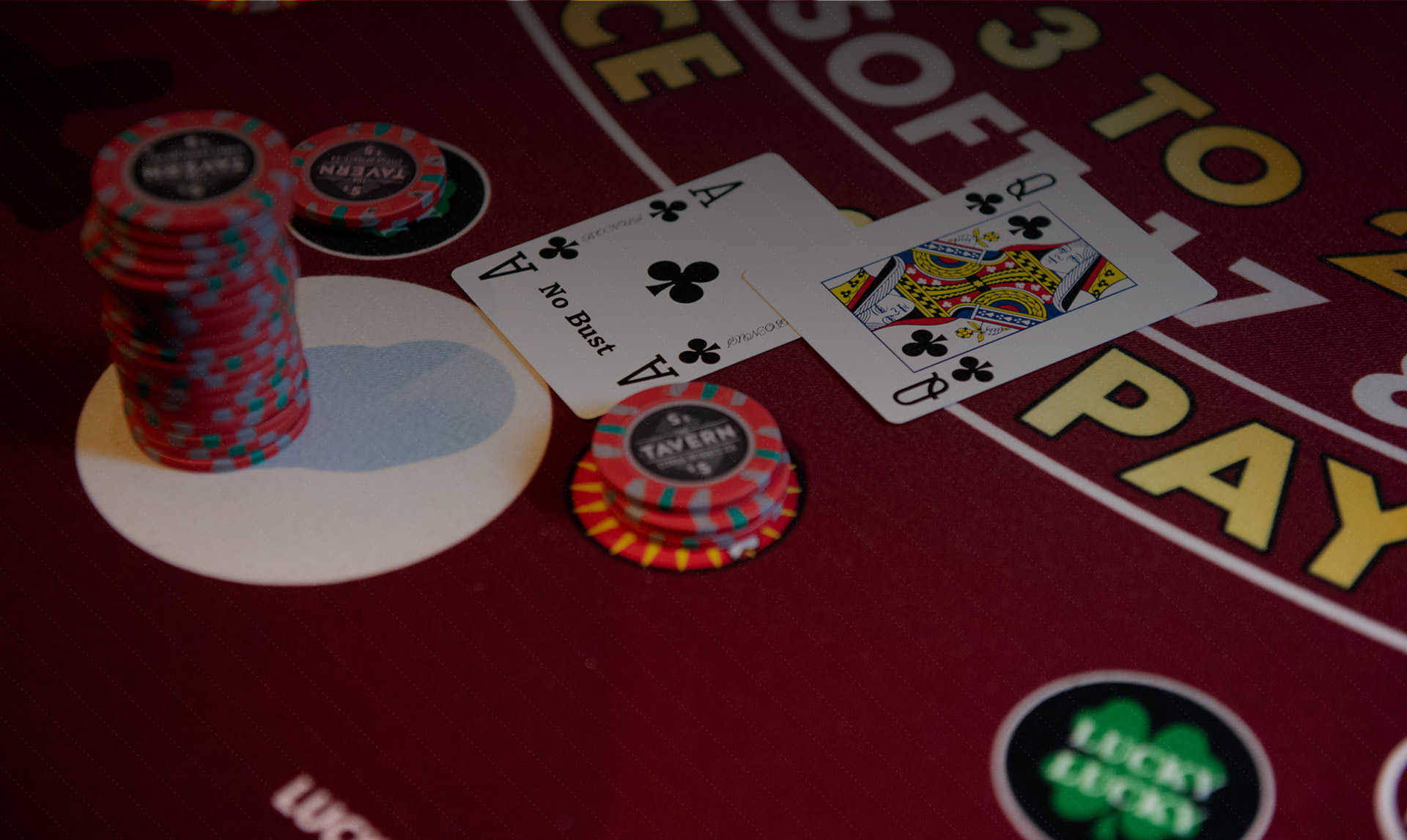 Poker table with red felt and chips and two cards turned to show a Ace and Queen of clubs